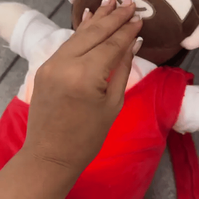 Mano que toca el peluche de Jesús y su corazón se ilumina